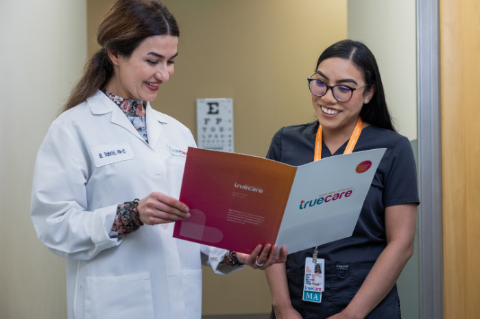 A picture of a woman applying for a job and smiling because she found her professional calling after learning about the 6 defining TrueCare core values.