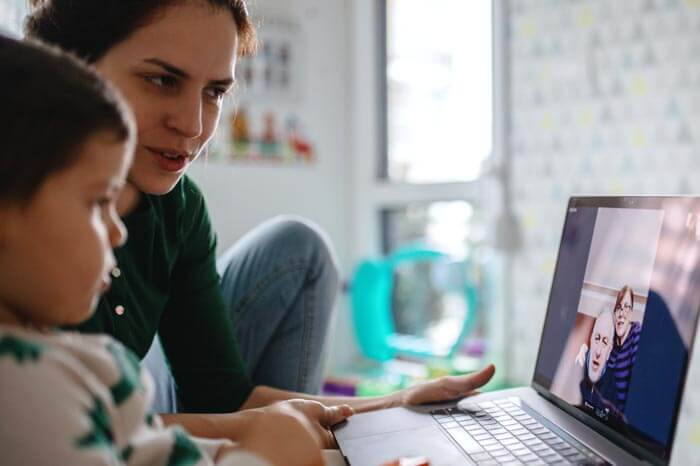 durante la pandemia covid un niño pequeño y una madre haciendo una videollamada en una computadora portátil con los abuelos